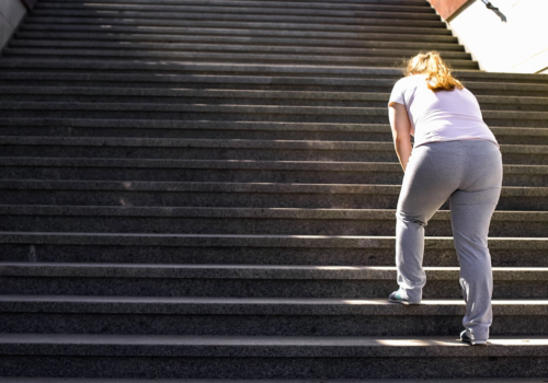 Woman Struggling To Climb Stairs